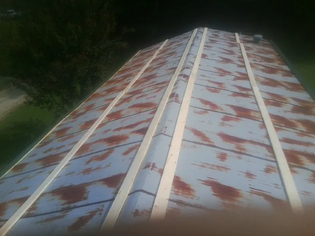 Rusted metal roof panels with new wood purlins before replacement — Storm Damage Roof Repair in Spruce Pine by Roofing Brothers