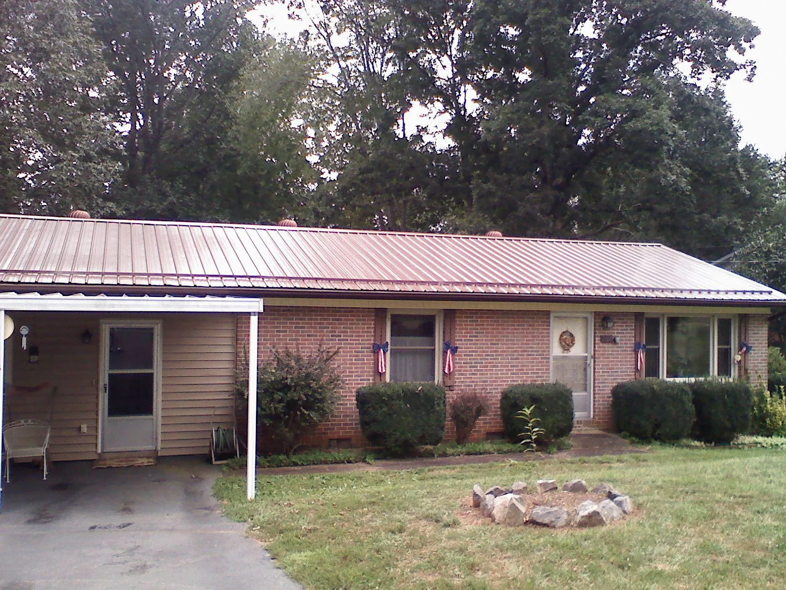 Bronze metal roof and carport on a brick ranch home — Roof Repair work by our crew in Spruce Pine